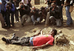 Periodistas fotografían a un hombre herido durante los disturbios en Reiger Park, Sudáfrica, en 2008. Foto © Siphiwe Sibeko / Reuters. www.20minutos.es